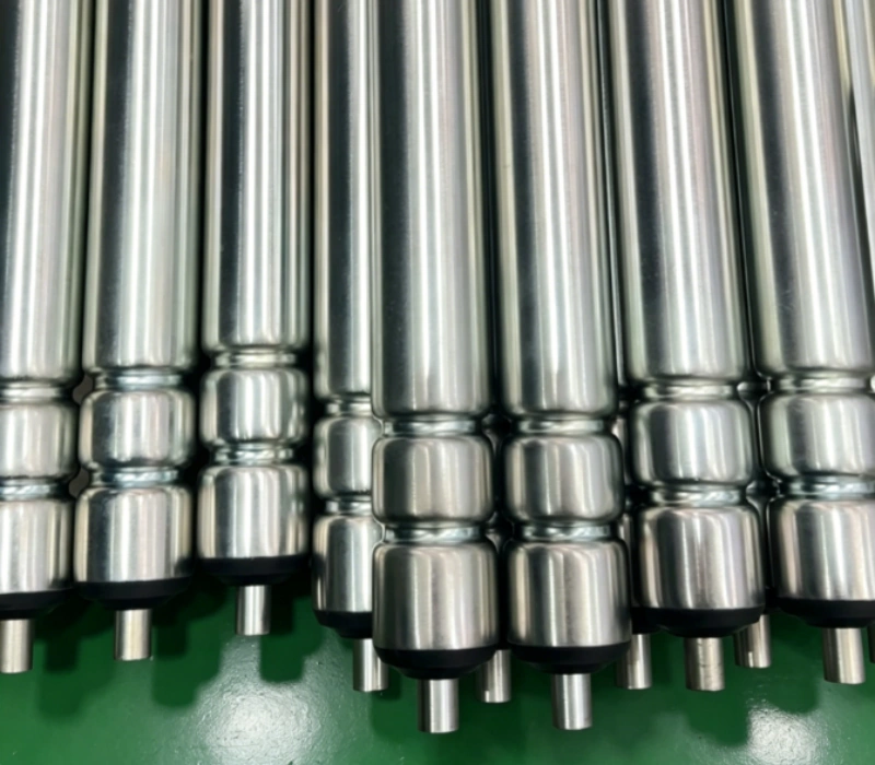 Double-O grooved conveyor roller carrying round-belt drive from one roller to the next