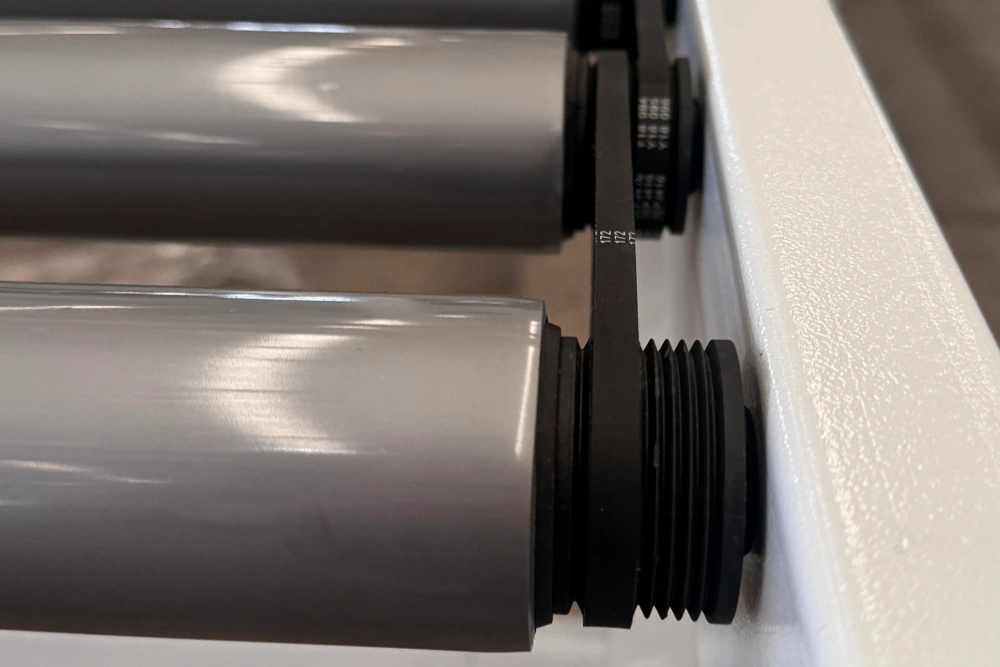 PVC-sleeved poly V driven rollers on a powered roller conveyor with poly V belt at the side